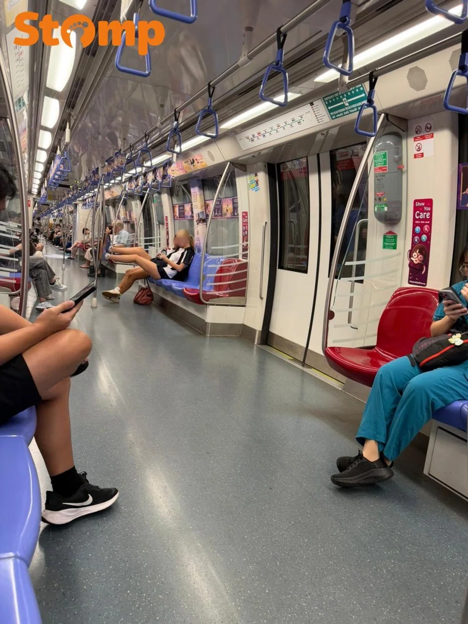 The passenger was seated with her legs outstretched and her Adidas-covered feet resting on the vertical metal pole.