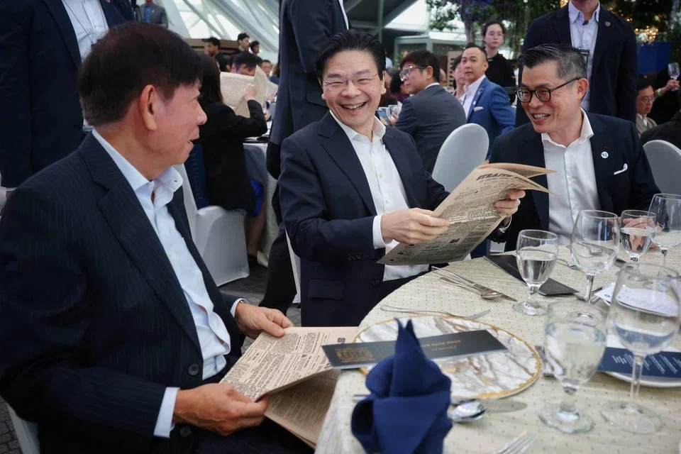 PM Lawrence Wong with a replica copy of the first edition of The Straits Times at a gala dinner on July 11 in celebration of the paper’s 180th anniversary. With him are SPH Media chairman Khaw Boon Wan (left) and ST editor Jaime Ho.