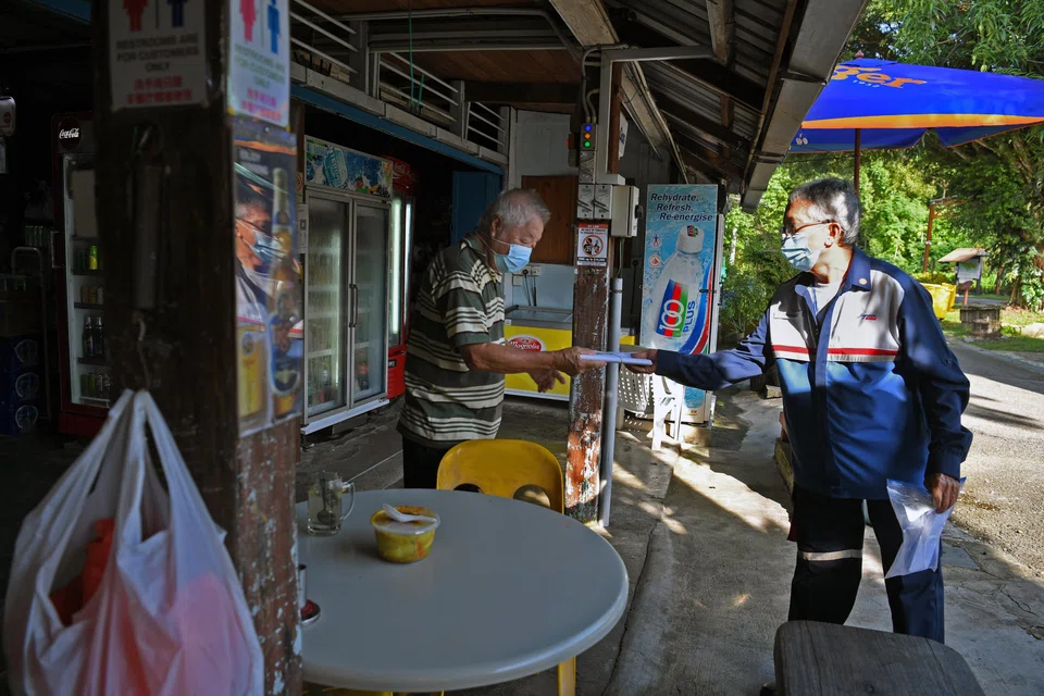 Postman Shahruddin Datok delivering a letter to the Season Live Seafood Restaurant (left) on Pulau Ubin in 2021.