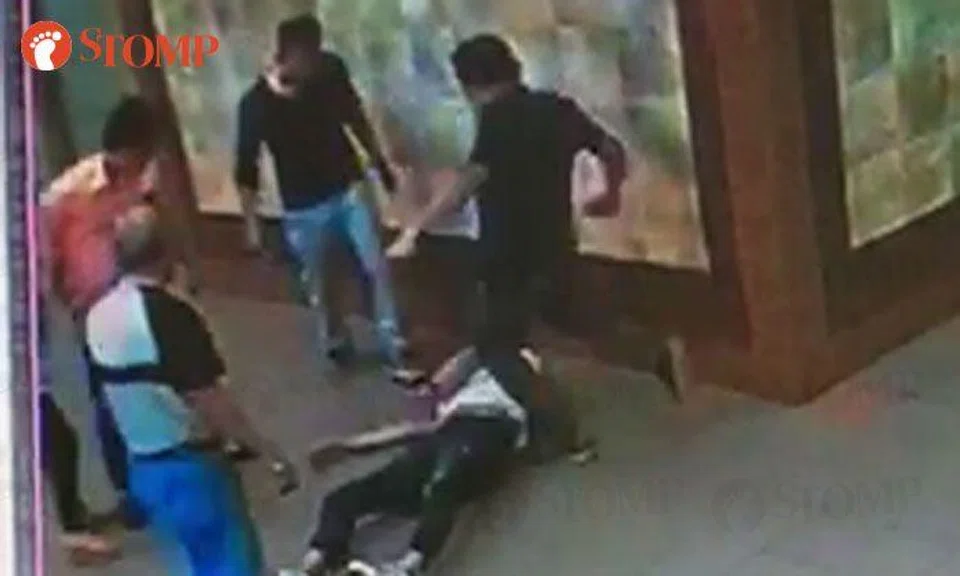 Group of men punch and kick guy at Golden Mile Tower