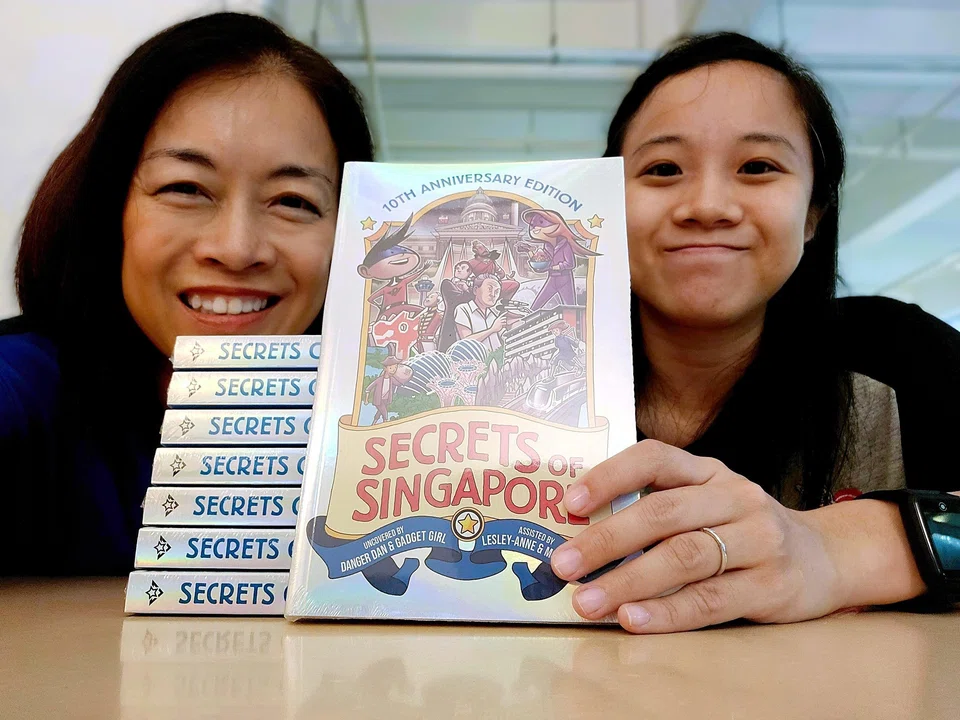 Monica Lim (left) and her daughter Lesley-Anne Tan with their book, Secrets Of Singapore: 10th Anniversary Edition, which has a holographic cover.