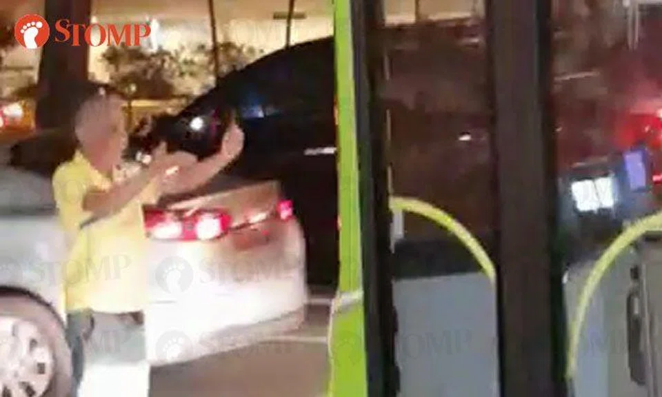 Uncle blocks bus and bangs on its door at Clarke Quay, gestures for it to come at him