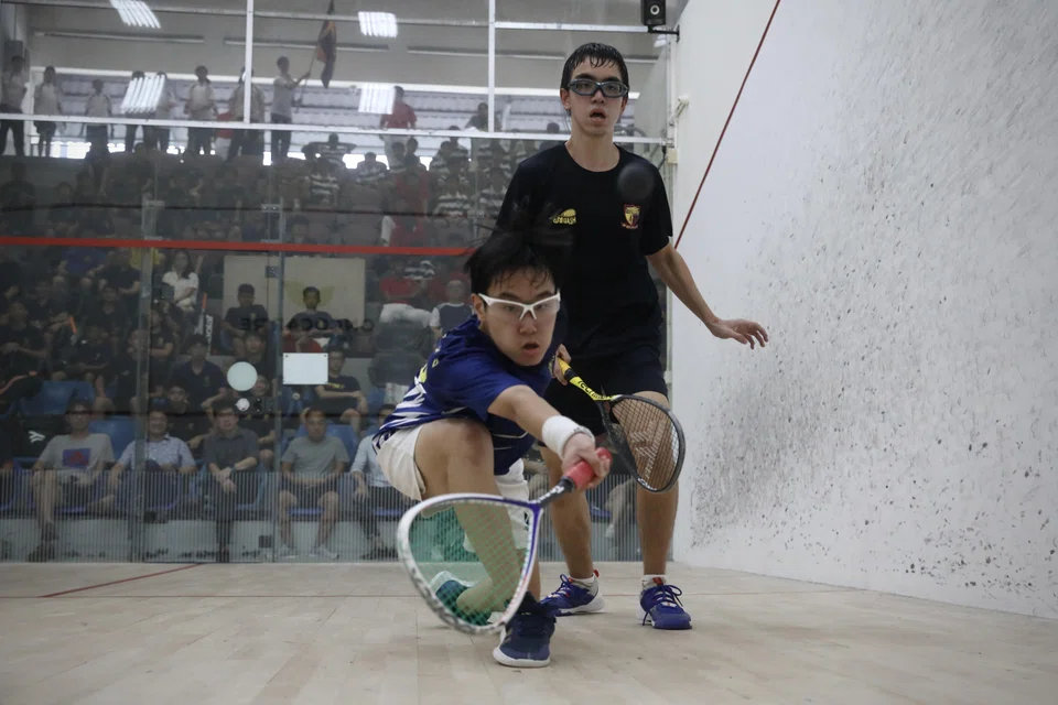 Nic Tay (bottom) lunges for the ball in his match against Hugo Tay. 
