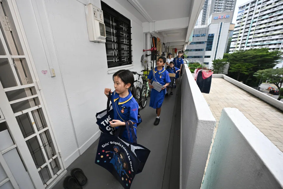 (From left) Pupils Ferrina Phuah Ru Xu and Nakshatra Yogaraja and other Girls’ Brigade members deliver wish items to beneficiaries at Jalan Kukoh on May 22.