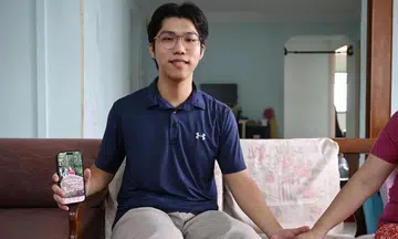 Caregiving is not a burden forced upon him but a conscious choice, says NTU undergraduate Samuel Chew as he holds his mother’s hand and shows a digital photo of his late father.