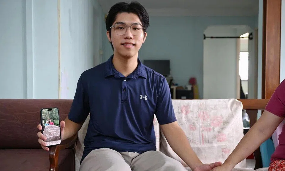 Caregiving is not a burden forced upon him but a conscious choice, says NTU undergraduate Samuel Chew as he holds his mother’s hand and shows a digital photo of his late father.
