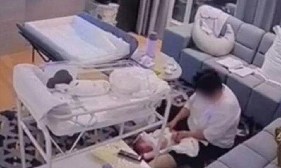 CCTV footage showing the nanny changing the baby's diaper.PHOTO: SHIN MIN DAILY NEWS