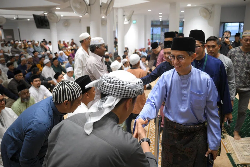 Prof Faishal Ibrahim (right) greets congregants before the Hari Raya Aidiladha prayer at the recently upgraded Masjid Darul Makmur.