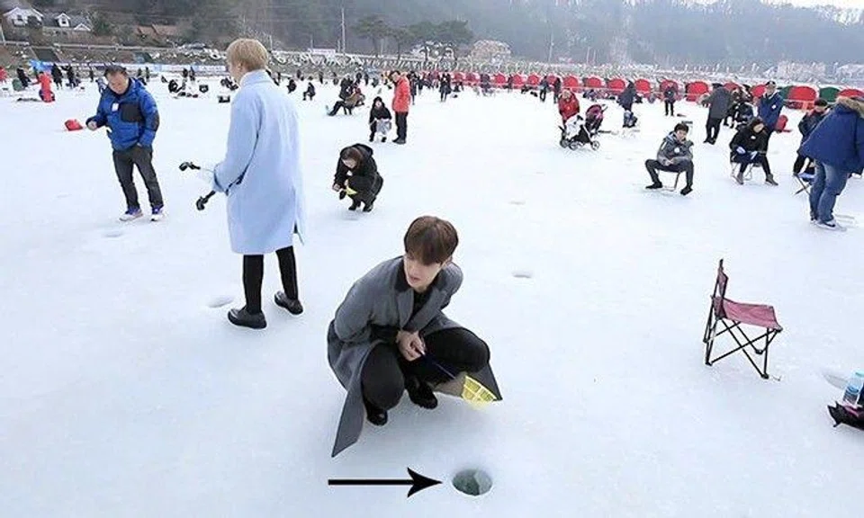 Why are people gathered around holes in the ice?