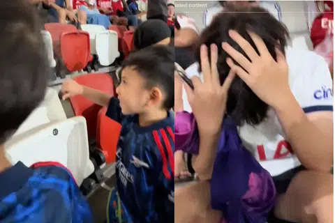 Young Arsenal supporters in Singapore give Spurs fan the thumbs down