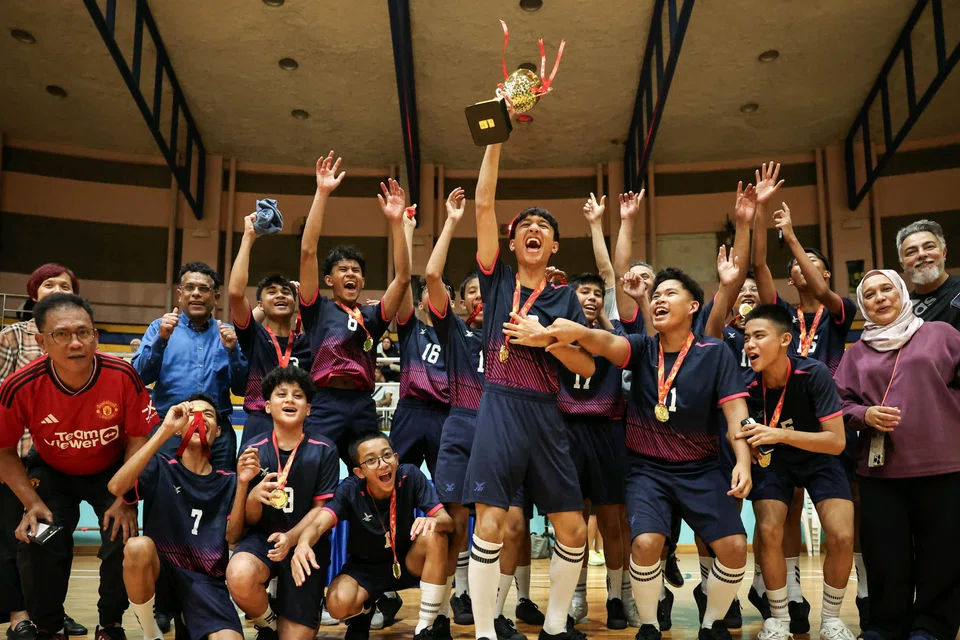 Marsiling Secondary School's Muhammad Herzy Khaliff lifting the trophy after leading his team to the 2025 National School Games B Division sepak takraw title on March 10.