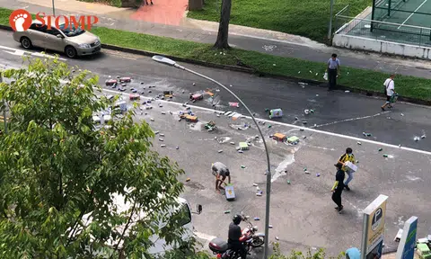 Passers-by help to clear road after cartons of beer fall from truck in Yishun