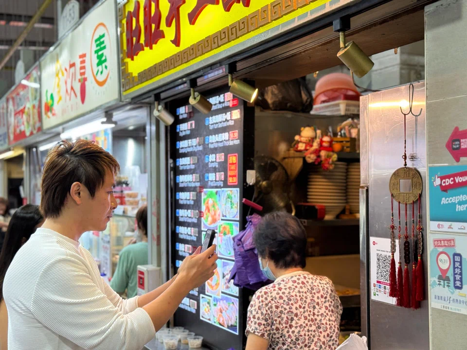 A customer uses PayLah to scan and pay for his meal at a hawker stall. 