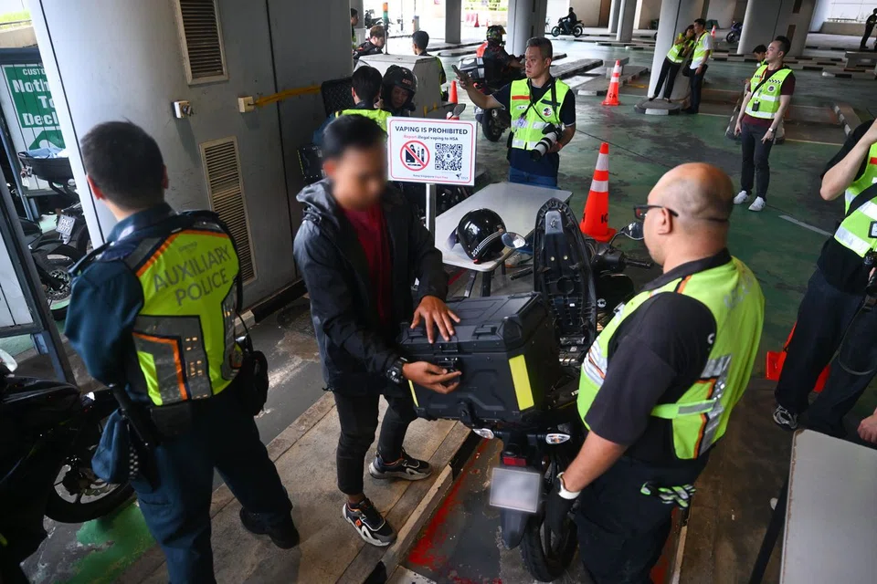 Officers conducting checks on motorcyclists at Tuas Checkpoint on Aug 22.