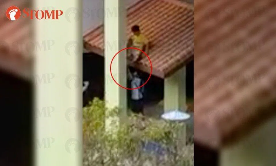 Boys in uniform tug at legs of friend sitting on roof at Jurong West carpark 