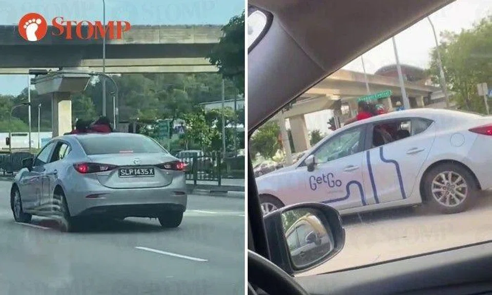 The video shows the silver Mazda with the heads and shoulders of two people above the roof of the car coming to a stop at the traffic junction that joins Punggol East road.