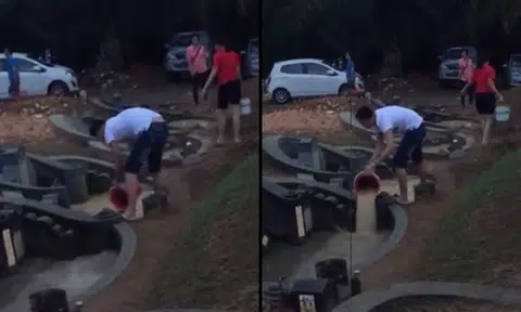 Man scoops water from flooded grave in Malaysia -- only to dump it in another