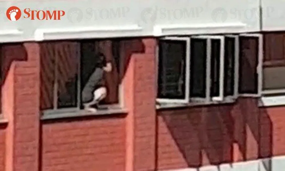 Woman squatting down on ledge to clean windows at Toh Yi Dr is "accident waiting to happen"