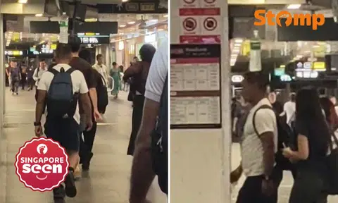 Man walks with water bottle on head at Woodlands MRT station