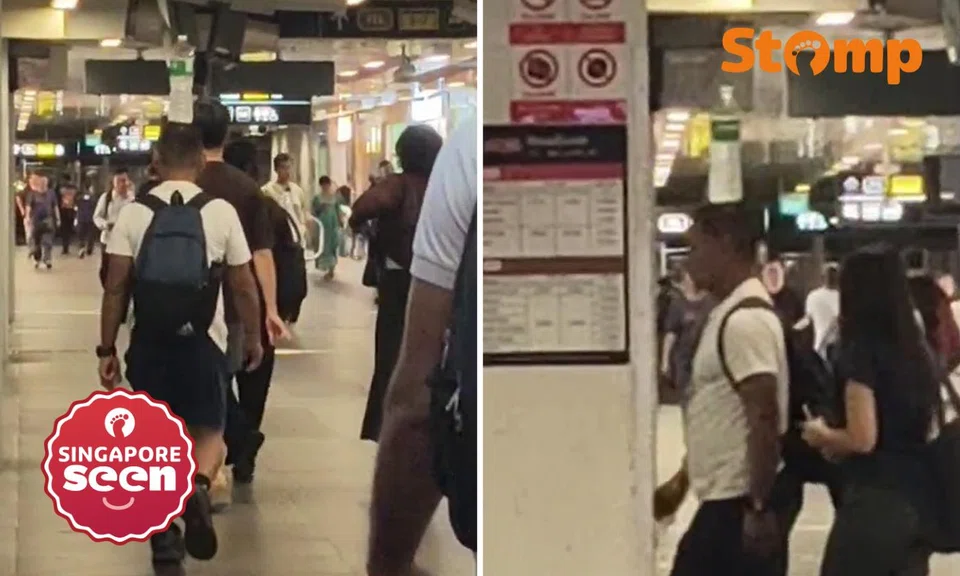 Man walks with water bottle on head at Woodlands MRT station