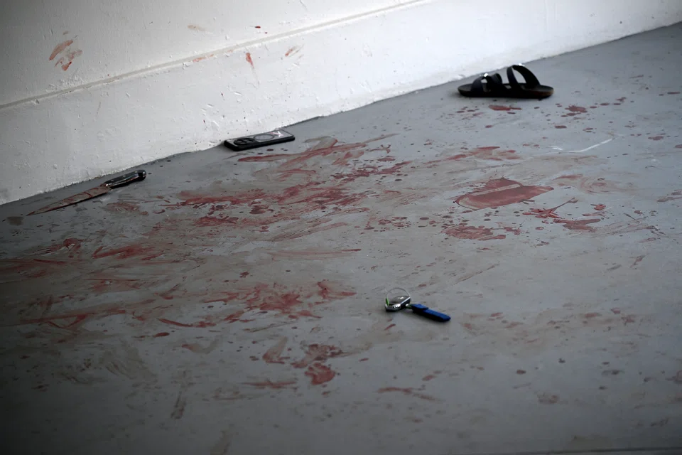 A knife, a watch, a mobile phone, a set of car keys and a slipper lying on the bloodstained floor on Sept 24. PHOTO: ST FILE