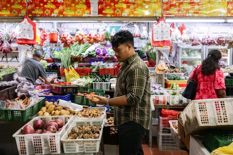 Chef and content creator Azfar Maswan looking at fingerroot being sold at stall 90 in Tekka wet market.