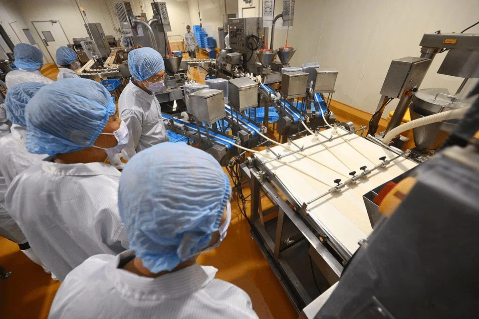 Participants observing machinery during a tour at the Thong Siek Group factory on Sept 5.