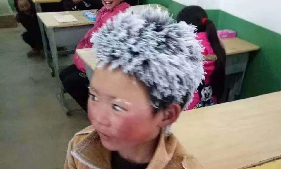 Yunnan boy has icicles on his hair after braving the cold -- to attend school