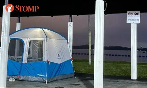 Inconsiderate family sets up camping tent inside Pasir Ris Park shelter where sign says no camping
