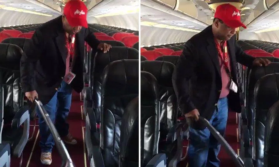 AirAsia CEO Tony Fernandes does a bit of housekeeping on board flight AK6306 