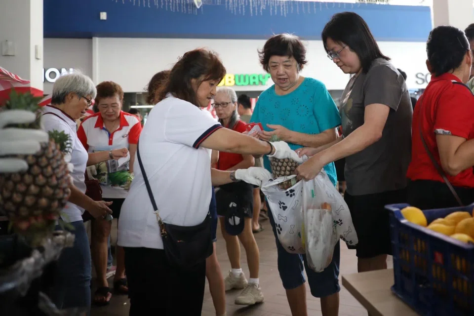 Residents collecting fruits and vegetables at the $1 Marketplace event in Ci Yuan Community Club in Hougang on March 29.