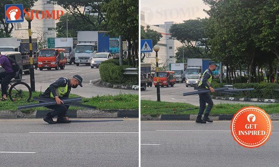 On-duty Certis officer picks up metal trunking that fell from lorry at Gambas Avenue