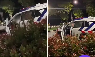 woman assisting with investigations for entering stationary police car and posing for photos