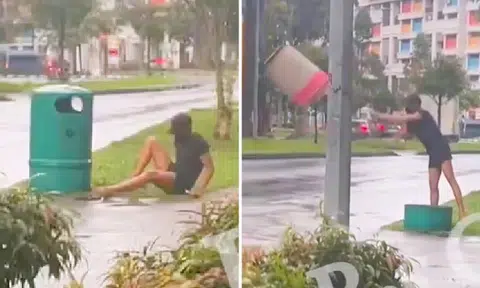 Man gets up from ground, rages at rubbish bin and tosses it onto road -- along with his phone