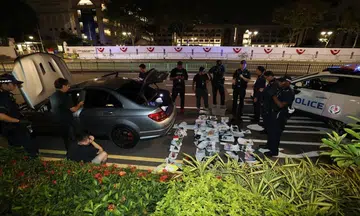 Officers were seen removing e-cigarettes from sealed boxes and sorting them into evidence bags next to the vehicle.