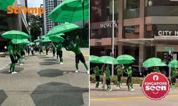 ‘Green men’ hold up umbrellas for people at Lau Pa Sat