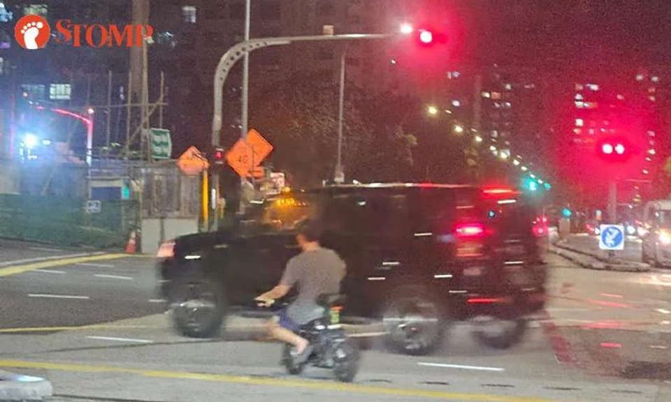 A man was riding an e-bike near a car at Punggol. 