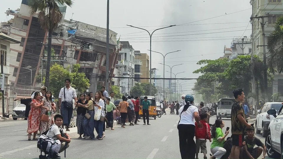 People gathering on a Mandalay street near damaged buildings after an earthquake struck Myanmar on March 28.