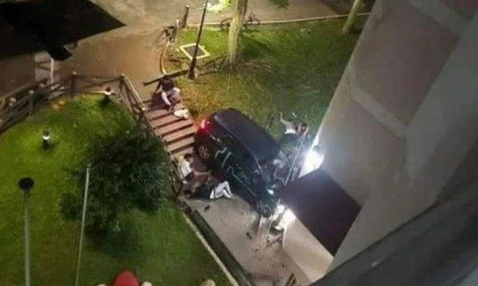 Men seen lying on ground after GetGo car skids and crashes into Jurong East HDB block