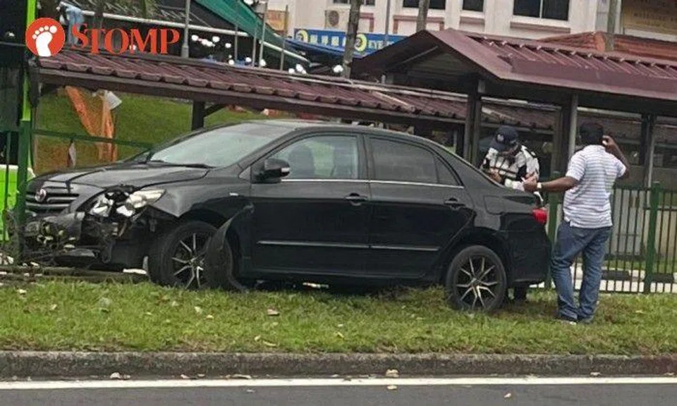 Stomper Wilson shared a photo of a damaged black Toyota Vios, which had stopped next to the railing on the grass verge of the centre road median with a Traffic Police motorcycle nearby