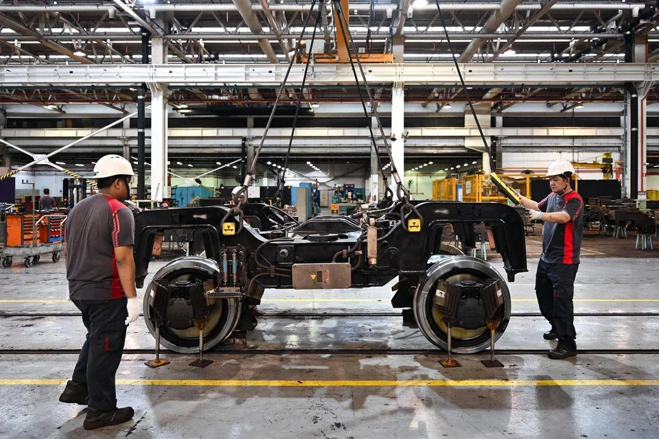 Technical officers putting the bogie frame onto a wheelset inside the workshop at Bishan Depot on March 11, 2025.
