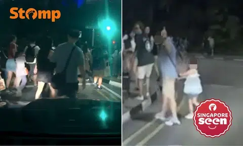 Man crosses road dangerously with child, flashes middle finger after Disney fireworks in Marina Bay