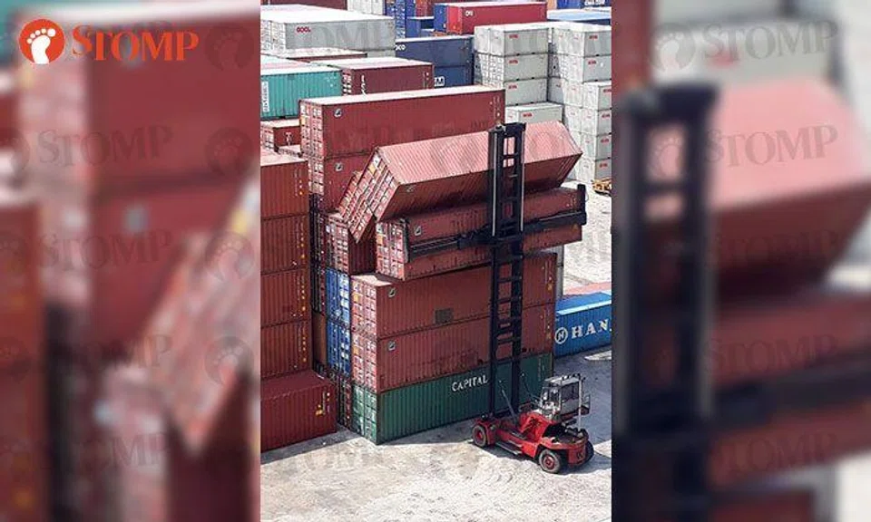 Toppled containers at storage yard in Penjuru Lane hang precariously over forklift