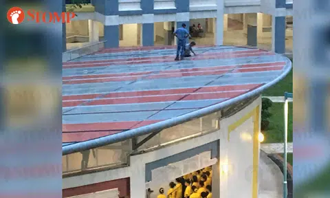 Men walk on roof of multi-purpose hall without any safety equipment