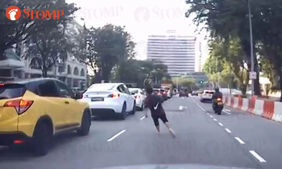 boy runs around cars at Kim Seng Road
