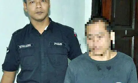 The accused (right) being led away by an officer. PHOTO: NEW STRAITS TIMES