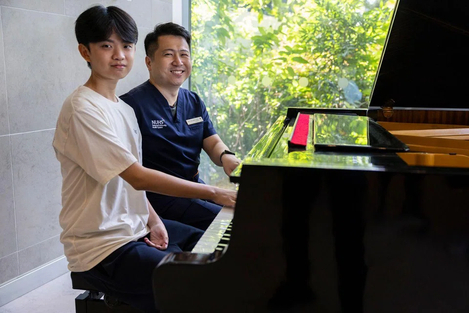 Ryan Lim (left) from Ahmad Ibrahim Secondary School and his doctor Lee Yang Yang playing the piano at NUHS Tower Block on Aug 25.