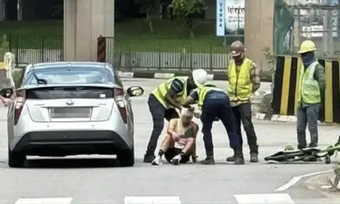 Kind-hearted migrant workers bandage cyclist's head after he's hit by car