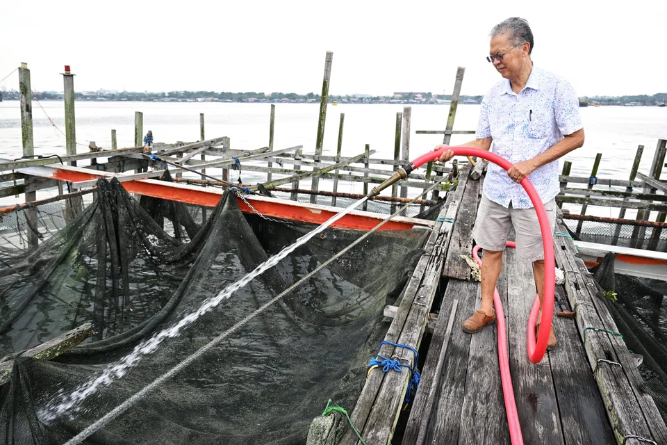 Mr Timothy Ng washing the nets of kelong E63, which he purchased in 2004.