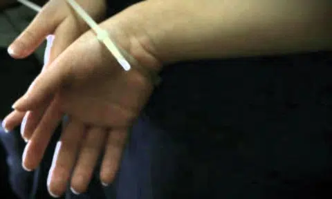 Hands bound with cable tie